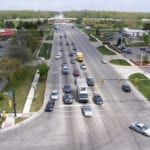 Busy multi-lane road with cars lined up at a traffic light.