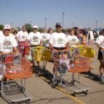 Men and women in white tee-shirts with orange shopping carts