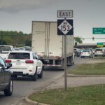 Traffic congestion on a highway with a sign for East Route 152.