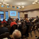 Audience attentively watching a presentation in a conference room.